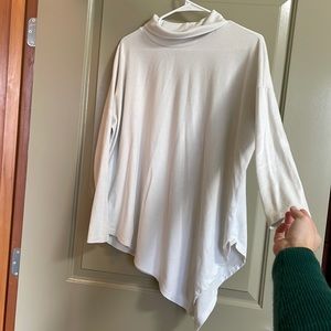 White long sleeve top with loose turtle neck, tapered hemline